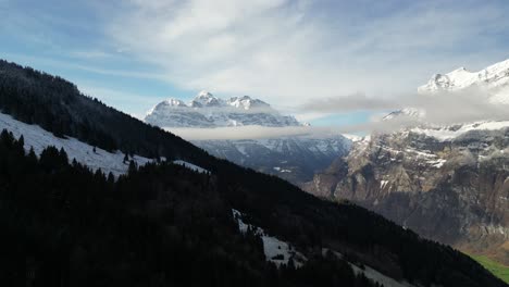 Ladera-Boscosa-Oscura-En-La-Sombra-Con-Bandas-De-Nubes-En-Capas-Sentadas-Debajo-De-La-Montaña-Suiza