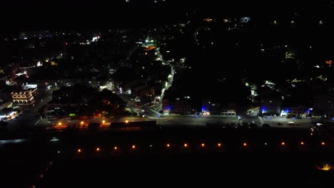 Vista-Aérea-Nocturna-De-Un-Bullicioso-Paisaje-Urbano-Con-Intensas-Luces-De-Calle-Y-Tráfico