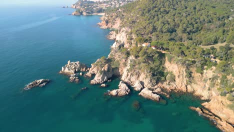 Behold-Lloret-De-Mar's-stunning-aerial-vistas,-featuring-the-serene-blue-waters-and-deluxe-tourism-hubs-of-Santa-Cristina-and-Cala-Treumal-along-its-Mediterranean-coast