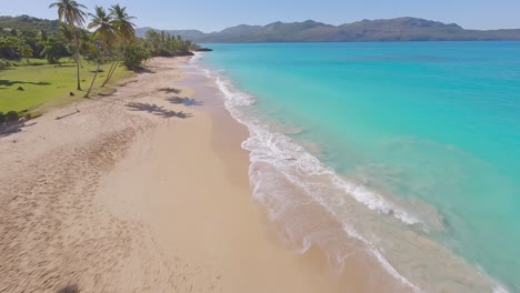 Epischer-FPV-Drohnenflug-über-Palmen-Zum-Malerischen-Sandstrand-Und-Blauen-Ozean