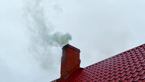 Smoke-rises-from-private-home-chimney-during-heating-season