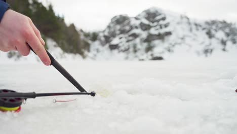 Schneeschaufeln-Aus-Eisloch-Mit-Angelrute-Auf-Dem-Boden-Im-Winter