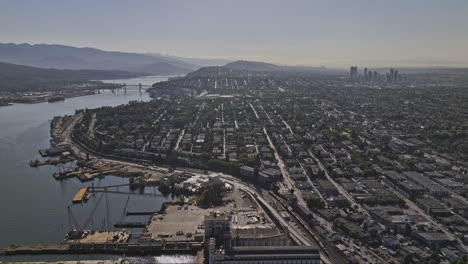 Vancouver-BC-Canada-Aerial-v91-drone-flyover-waterfront-industrial-area-capturing-harbour-views-and-cityscape-of-Hastings-Sunrise-neighborhood-and-Burnaby-city---Shot-with-Mavic-3-Pro-Cine---July-2023