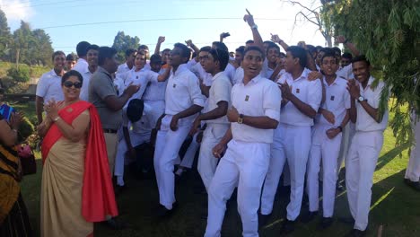 School-boys-wearing-white-uniforms-joyfully-singing-and-dancing-in-a-park-in-Nuwara-Eliya,-Sri-Lanka