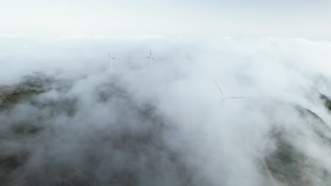 Drone-flight-over-wind-generator-rotors-turning-in-clouds-on-Madeira-mountain