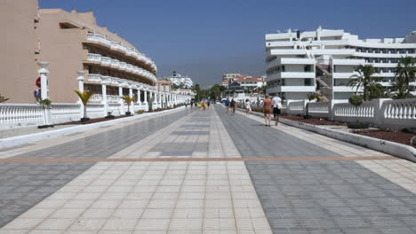 Un-Soleado-Paseo-Bordeado-De-Palmeras-Y-Balaustradas-Blancas,-Que-Invita-A-Pasear-Junto-A-Los-Balnearios-Y-Hoteles-De-Los-Christianos-Tenerife