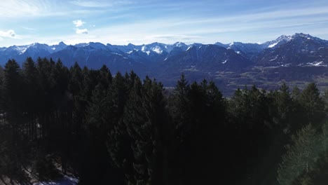 Drones-Vuelan-Sobre-El-Bosque-Y-Revelan-Un-Increíble-Paisaje-Montañoso-Invernal-Cubierto-De-Nieve-En-Un-Hermoso-Día-Soleado-Con-Un-Cielo-Azul-Claro-En-Austria