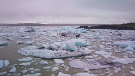 Paso-Elevado-Sobre-Una-Enorme-Laguna-Glaciar-Llena-De-Icebergs-Flotantes-En-Islandia
