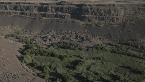 AERIAL-DRONE-SHOT-OF-SUN-LAKE-DRY-FALLS-CLIFF-SIDE-MOVING-FORWARD