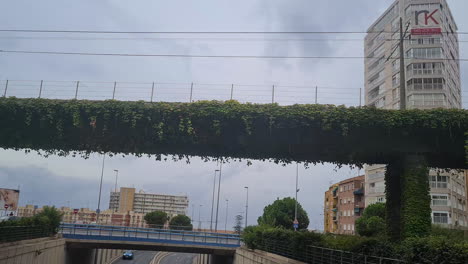 Puente-del-Tram-Bridge-in-Alicante,-Spain,-Railway-Bridge-Overgrown-With-Plants,-Roundabout-POV