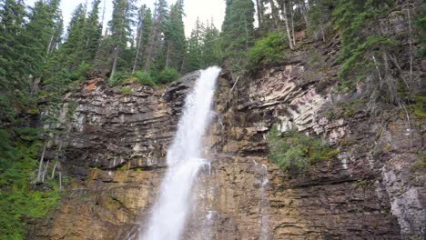 Virginia-Falls-waterfall-in-Glacier-National-Park,-tilt-down-handheld