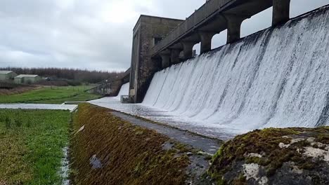 Mossy-Cefni-dam-concrete-engineering-barrier-gate-pouring-slow-motion-from-overflow
