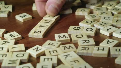 Die-Rechte-Hand-Des-Mannes-Platziert-Scrabble-Buchstabensteine,-Um-Ein-Wortstudium-Zu-Machen
