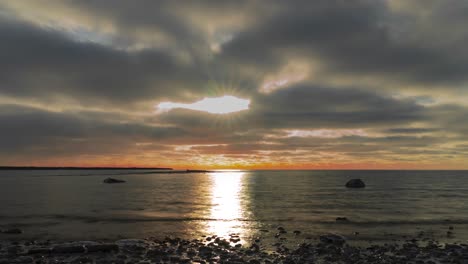 Dramatischer-Sonnenuntergang-über-Einem-Ruhigen-See-Mit-Wolken,-Zeitraffer
