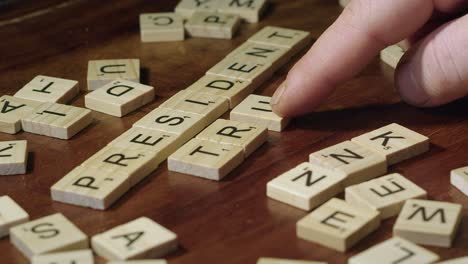 Scrabble-Azulejos-De-Letras-En-La-Mesa-Forman-Palabras-Presidente-Y-Triunfo