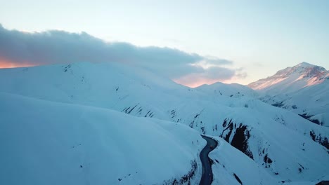 Wunderschöner-Sonnenuntergang-über-Einem-Hohen-Schneebedeckten-Berg-Im-Alborz-Gebirge,-Kaukasusklima-Im-Winter,-Malerische-Landschaft-Der-Wilden-Natur,-Natürlicher-Epischer-Schneefall,-Asphalt,-Kurvenreiche-Straße,-Autofahren