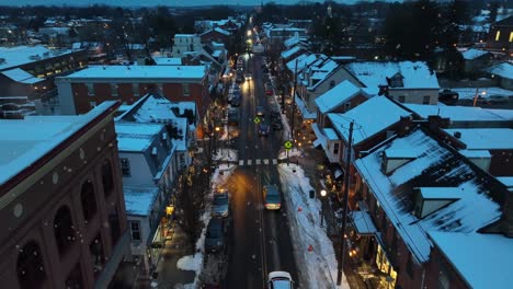 Schneefall-In-Einer-Amerikanischen-Stadt-Mit-Verkehr-Auf-Der-Hauptstraße-In-Der-Abenddämmerung