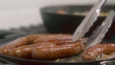Breakfast-sausages-are-gently-flipped-as-they-cook-in-a-cast-iron-skillet