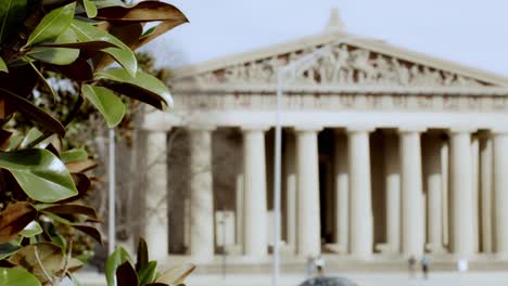 The-Partehnon-building-in-Nashville,-Tennessee-with-magnolia-tree-in-focus-in-foreground-stable-shot