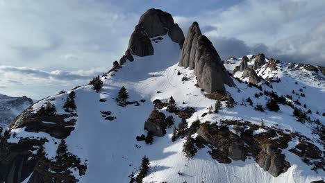 Montañas-Ciucas-Con-Parches-De-Nieve-Bajo-Un-Cielo-Azul-Claro,-Principios-De-Primavera,-Vista-Aérea