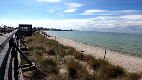 Sonnenbeschienenen-Holzsteg-Am-Sandstrand-Auf-Der-Halbinsel-Hel,-Ostsee,-Woiwodschaft-Pommern,-Polen