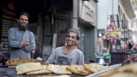 Cinematic-Shot-street-up-on-the-road-a-brother-is-making-a-cool-omelet-on-a-cool-rack-and-looking-at-the-camera