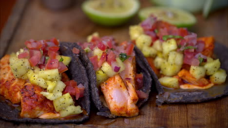 Zeitlupen-Nahaufnahme-Einer-Variante-Der-Traditionellen-Mexikanischen-Tacos-Al-Pastor-Mit-Mariniertem-Lachs-Auf-Blauen-Maistortillas-Und-Ananas