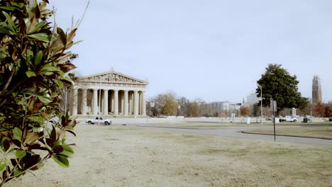 The-Partehnon-building-in-Nashville,-Tennessee-wide-shot-and-magnolia-tree-in-the-foreground-with-video-panning-right-to-left