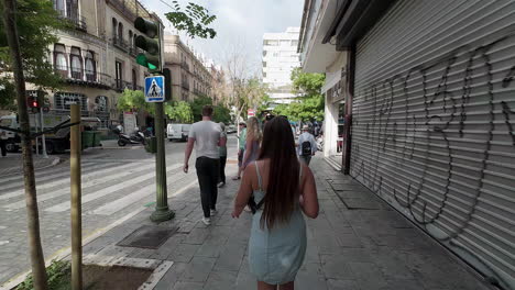 Beautiful-young-girl-walks-in-streets-of-Seville,-slow-motion