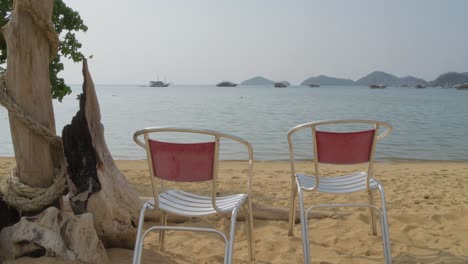 Stühle-Am-Strand-Mit-Blick-Auf-Das-Blaue-Meer-In-Labuan-Bajo,-Indonesien