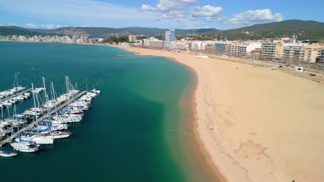 From-the-sky,-Palamós-unfolds-as-a-picturesque-tapestry-of-sandy-beaches,-rocky-coves,-and-emerald-green-hillsides