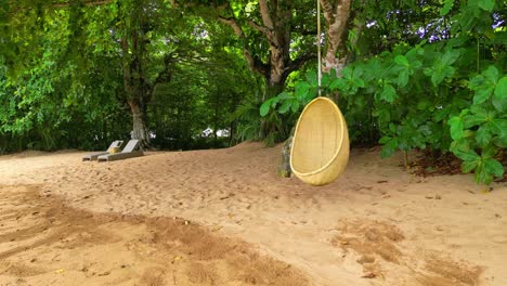 A-close-up-view-from-a-hanging-chair-and-beach-lounge-chairs-at-a-sundy-beach-in-Prince-Island,Africa