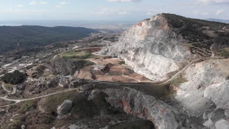 Aerial-view-quarry-open-pit-sunny-day-big-city-background