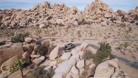 Una-Camioneta-Mercedes-Sprinter-Estacionada-En-El-Parque-Nacional-Joshua-Tree-Mientras-Un-Dron-Vuela-Hacia-Atrás