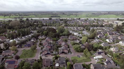 Dutch-green-residential-neighbourhood-with-countryside-meadows-on-the-other-side-of-the-river-IJssel-in-flat-landscape-on-the-horizon