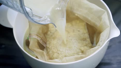 Verter-Agua-En-Una-Bolsa-De-Nueces-Llena-De-Pulpa-De-Jengibre-Fresco-Para-Hacer-Una-Bebida-Deliciosa-Y-Saludable