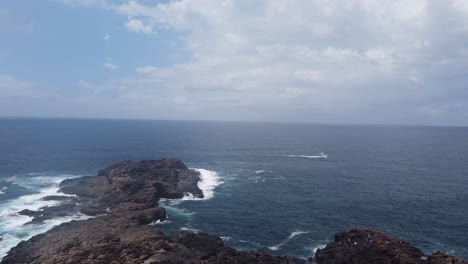 Eine-Drohne-Steigt-über-Eine-Felsige-Halbinsel-Auf-Und-Zeigt-Im-Hintergrund-Den-Pazifischen-Ozean,-Während-Die-Wellen-Gegen-Die-Felsen-Schlagen