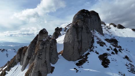 Schneebedeckte-Ciucas-Berge-Unter-Blauem-Himmel,-Mit-Schroffen-Gipfeln-Und-Einem-Gefühl-Von-Abenteuer,-Luftaufnahme
