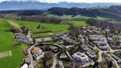 Schweizer-Stadt-Mit-Gebäuden-Und-Häusern-Neben-Grünen-Grasfeld-Auf-Einem-Hügel