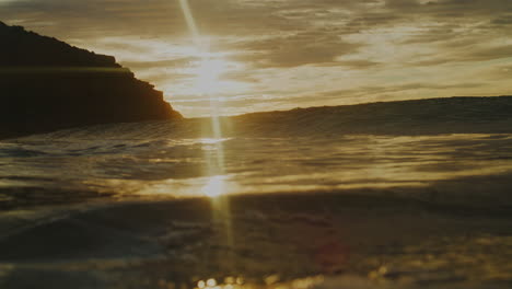 El-Sol-Alto-En-El-Cielo-Hace-Que-Un-Rayo-De-Luz-Brille-Sobre-El-Agua-Mientras-La-Ola-Rompe-En-La-Superficie