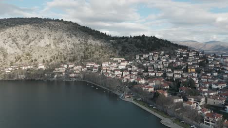 A-drone-shot-towards-a-village-mountain,-warm-weather,-flying-above-a-dreamy-lake,-4K-video,-European-spring-nature,-beautiful-landscape,-white-scenic-clouds