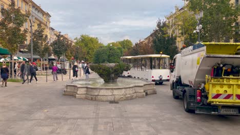 City-square-in-Aix-en-Provence-with-tourist-train-and-fountain,-lively-atmosphere,-casual
