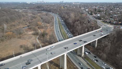 Diese-4K-Drohnenaufnahme-Zeigt-Den-Verkehr-Zur-Hauptverkehrszeit-Auf-Dem-Don-Valley-Parkway,-Der-Unter-Der-Leaside-Bridge-In-Toronto,-Kanada-Hindurchführt.