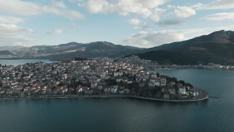 A-drone-shot-of-a-village-mountain,-warm-weather,-flying-above-a-dreamy-lake,-4K-video,-European-spring-nature,-beautiful-landscape,-white-scenic-clouds