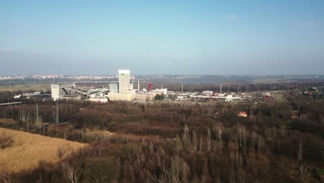 Complejo-Industrial-De-La-Mina-De-Carbón-Darkov-Rodeado-Por-Una-Zona-Boscosa,-La-Ciudad-Visible-Al-Fondo-Bajo-Un-Cielo-Despejado