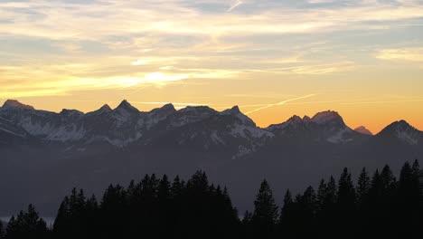 Drone-Vuela-Sobre-Montañas-Y-En-La-Distancia-Altas-Montañas-Con-Nieve-En-Amden,-Weesen,-Glarus,-Suiza,-Humor-De-Amanecer