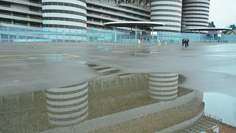 History-and-architecture-reflected-in-puddle,-San-Siro-Stadium