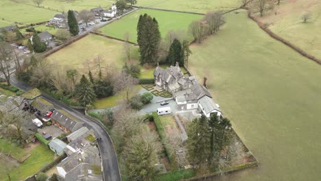 Drone-doing-a-semi-orbit-of-Grasmere,-a-mountain-village-located-in-Cumbria,-at-Westmorland-and-Furness-in-Northwest-England-in-United-Kingdom