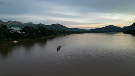 Boats-Move-About-The-Mekong-River-At-Sunset-In-Luang-Prabang
