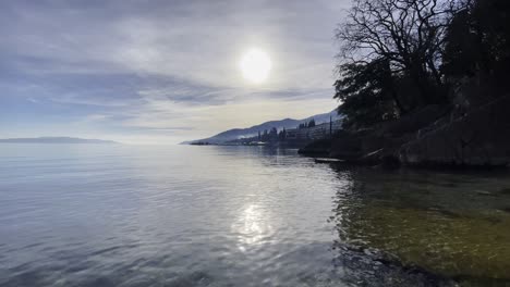 Resort-town-Sun-in-shore-with-island-in-distance,-Opatija,-Croatia